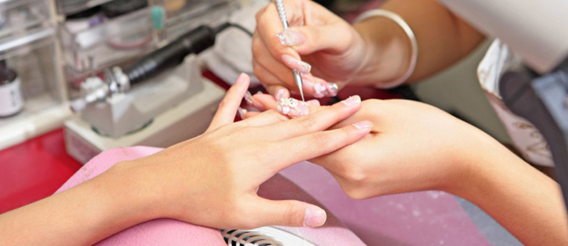A student becoming a Nail Technology Professional giving a client a manicure